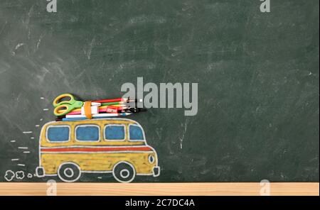 School creativity with with bus drawn on blackboard with colored pencils and school supplies Stock Photo