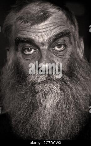 A black-and-white close-up facial portrait of an older Canadian man with a big, bushy grey beard, taken in Churchill, in northern Manitoba, Canada. Stock Photo