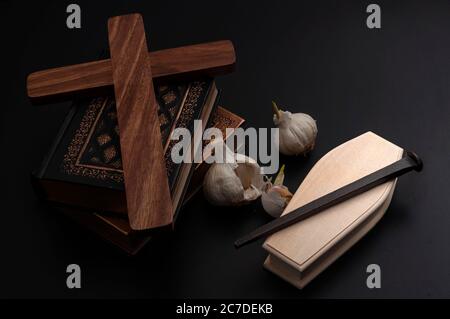 Halloween decoration, Mythology of Transylvania, legend of Dracula and vampire killing kit concept with books, fresh garlic, metal stake, wooden coffi Stock Photo