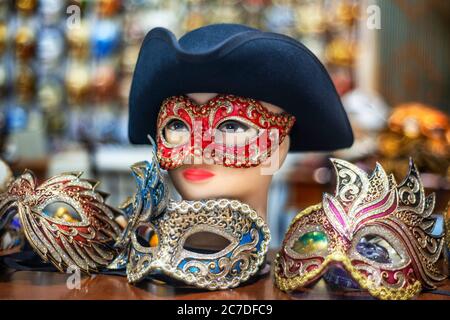Ornate carnival mask among colorful feathers in Venice, Italy. A display of Masquerade Ball Masks and Venetian Mask on sale in Bardolino Lake Garda Ve Stock Photo