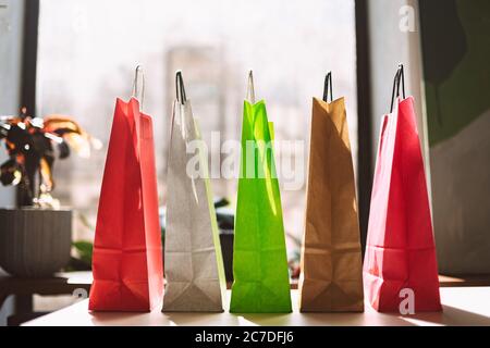 Close up colorful shopping bags on table with big window on background isolated Stock Photo