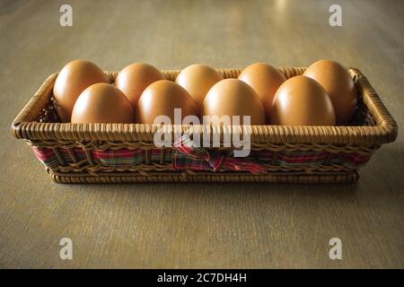 Rectangle basket filled with eggs on a wooden surface Stock Photo