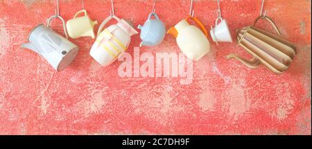 old coffee pots hanging on a rustic wall, panorama format Stock Photo