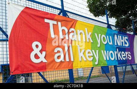 Rainbow banner attached to a fence, in gratitude to all NHS medical staff and keyworkers who are working during the UK Coronavirus pandemic crisis. Stock Photo