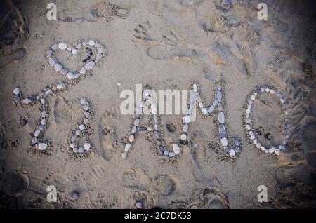 Overhead shot of sand on beach with stones spelling "Ti Amo" which means "I love you" in Italian Stock Photo