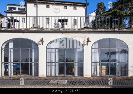 Horizontal shot of a gorgeous white house, with big windows and a terrace on the 2nd floor Stock Photo