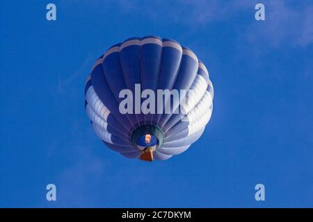 USA, Arizona, Monument Valley, Telephoto view of a hot air balloon firing up its gas flame to gain altitude at a balloon festival in the Navajo Tribal Park. Stock Photo