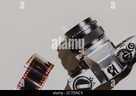 Geometric Flat lay set: vintage camera on light backgrounds with 35 mm filmstrip. Top view. Stock Photo