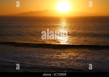 Sunset over the ocean and the island Stock Photo