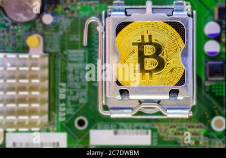 Gold Bitcoin mockup that installed on CPU socket on computer motherboard Stock Photo