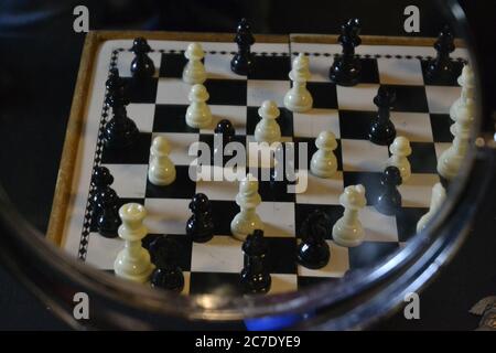 Chessboard. with white and black stones, with pawn, queen and king seen from above with reflection in the mirror, in zoom photo, Brazil, South America Stock Photo