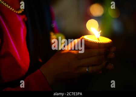 Closeup shot of a woman's hands holding a candle during the Yi Peng festival in Thailand Stock Photo