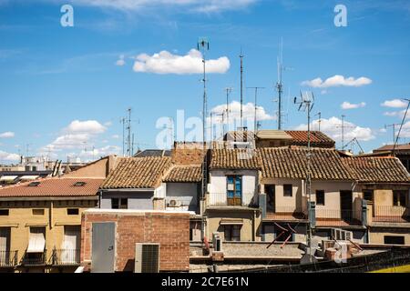 Horizontal shot of old house rooftops with tall antennas during a sunny day Stock Photo