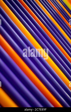 Purple and orange pattern plastic tubes straws diagonal background Stock Photo