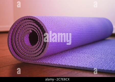 Purple yoga mat with soft pastel effect on the gym floor Stock Photo