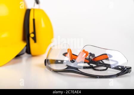 Safety glasses and a work helmet. Workwear for production workers. Light background. Stock Photo
