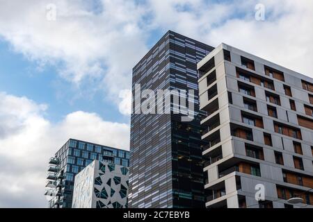 Modern business district in Oslo on cloudy epic sky, Norway, Scandinavia. Office urban buildings of the Barcode project in Bjorvika district low angle Stock Photo