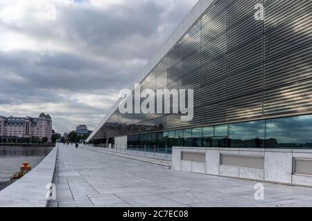 Oslo Opera House in Norway. Modern architecture exterior of the building with white granite and nice glass reflections with scenic clouds. Stock Photo