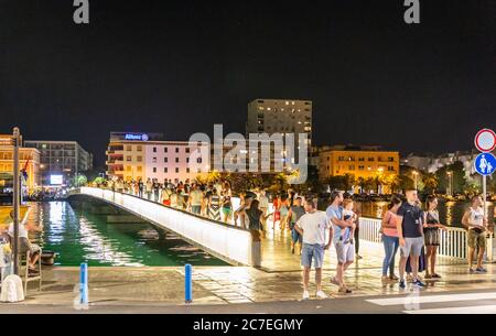 Many tourists cross the footbridge across the harbour to get from the extended area of the city to the old medieval walled city. Dalmatia, Croatia Stock Photo