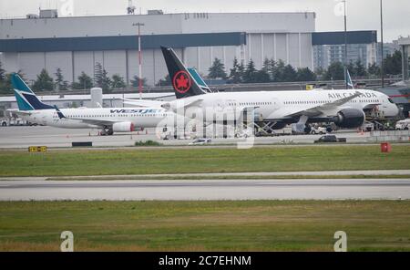 Richmond, Canada. 16th July, 2020. Aircraft are seen at the Vancouver International Airport in Richmond, British Columbia, Canada, on July 16, 2020. There have been a total of 31 international and domestic flights in July that have been flagged by the Canadian government for possible exposure to the novel coronavirus. Passengers near the affected rows are considered close contact and may be at risk of exposure, the government said on its website. Credit: Liang Sen/Xinhua/Alamy Live News Stock Photo