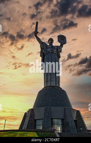 Giant Kiev's Motherland Monument, huge figure of a woman holding a sword and a shield. Dramatic late afternoon, golden sunset Stock Photo