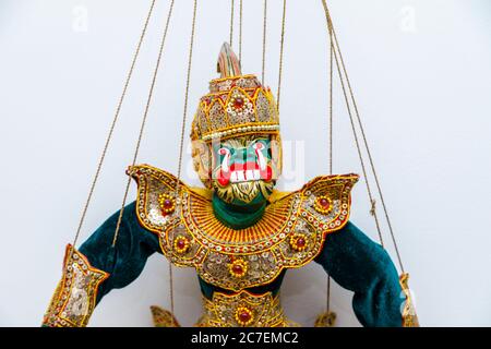 A traditional large green fearsome demon wooden puppet on strings, a souvenir of the far east typical of Bali, Lombok, Java and Indonesia Stock Photo