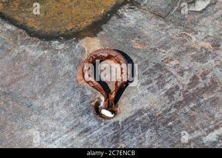 Old rusty mooring ring on Uunisaari Island shore rock in Helsinki, FInland Stock Photo