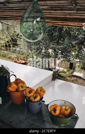 Vertical shot of orange bell peppers in different bowls with a blurred background Stock Photo