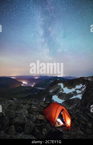 A vertical shot of a tent under the beautiful night sky with Milky Way ...