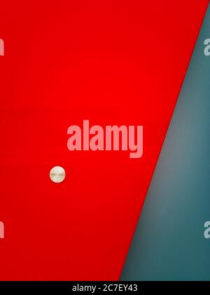 Vertical shot of a red and silver background with a small silver circle Stock Photo