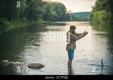 Fisher fishing equipment. Handsome man relaxing. Leisure on lake