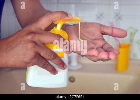 Hand sanitizer alcohol gel rub clean hands hygiene prevention of coronavirus outbreak. Man using bottle of antibacterial sanitiser soap. Stock Photo