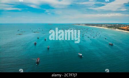 Many wooden Vietnamese traditional fisherman boats in the sea. Drone shot Stock Photo