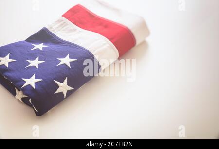 USA flag folded on white background. American flag closeup view, copy space. Memorial day and 4th of July, Independence day concept. Card, poster temp Stock Photo