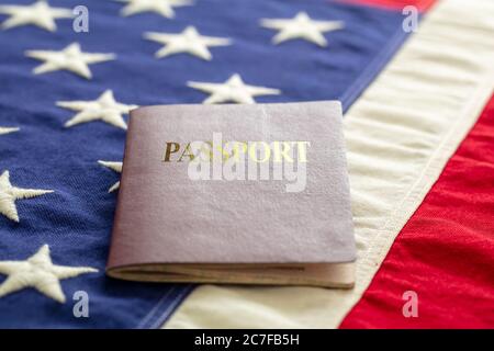 Passport on USA flag background, closeup view. Immigration, United States of America visa concept Stock Photo
