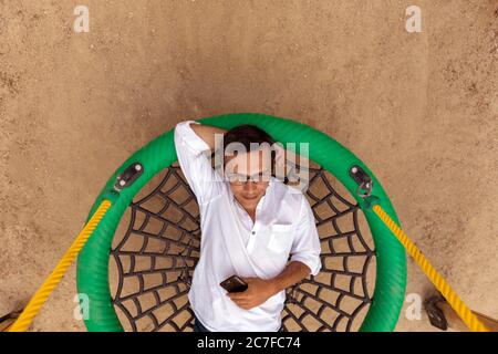 Carefree man on swing in park Stock Photo