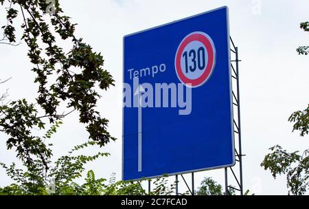 german highway direction sign, changed to speed limit 130 advice, outdoors Stock Photo