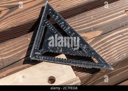 Carpentry measure, plan and design tools on raw wood background. triangular ruler and angle measuring Stock Photo