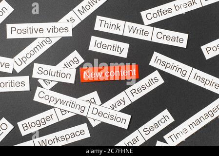 Cut paper inscription new content on a red background, surrounded by other inscriptions on a dark background. Word cloud concept Stock Photo