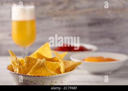 Crispy tortilla chips and sauces for a quick meal on the table. Stock Photo