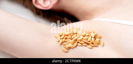 Wax orange beans on armpit of young caucasian woman. Depilation concept Stock Photo