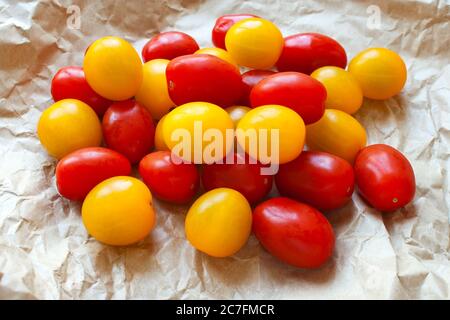 Red and yellow cherry tomatoes in a brown crumpled up paper bag Stock Photo