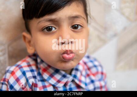 Portrait of cute little boy puckering his lips and looking at camera. Stock Photo