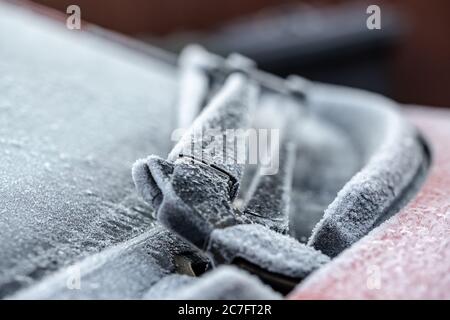 Shallow focus view of ice crystals formed on part of a car's windshield wiper blade assembly during winter. Stock Photo