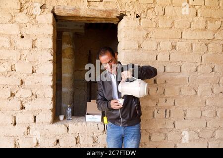 Raghba, Saudi Arabia, February 16 2020: A foreman on a construction site in Saudi Arabia pours tea. Stock Photo