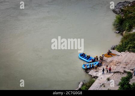 Tourists get onto a rafting boat on the banks of the River Ganges in the adventure town of Rishikesh in northern India Stock Photo