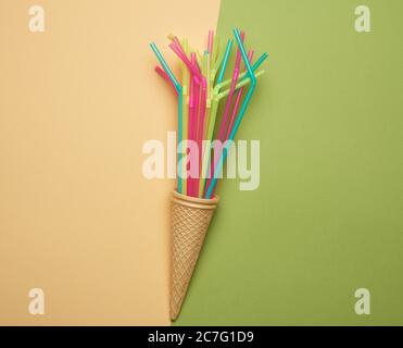 stack of plastic multi-colored cocktail tubes on a green background, close up Stock Photo