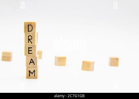 A word Dream written on the wood cubes. Dream lettering made of wooden cubes isolated on white Stock Photo