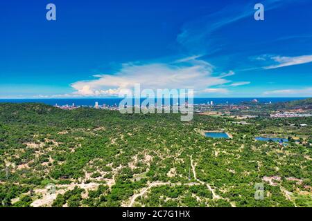 This unique photo shows the city of Hua Hin by the sea in the background and the dense nature in the foreground in summer Stock Photo
