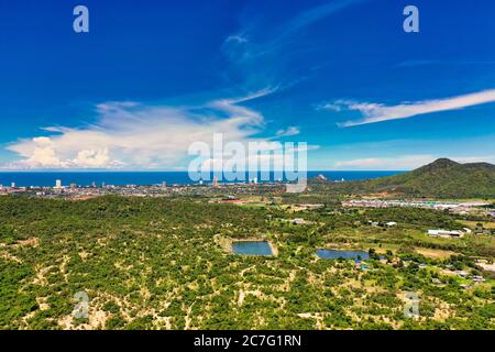 This unique photo shows the city of Hua Hin by the sea in the background and the dense nature in the foreground in summer Stock Photo